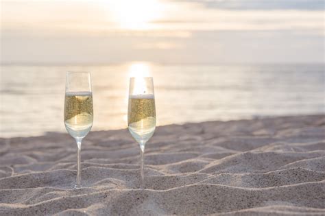 premium photo two glasses of champagne on the beach