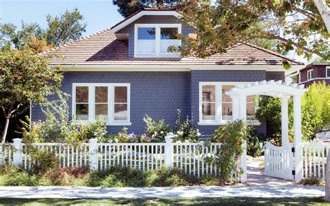 Modern Shingle Cottage With Flowering Garden And White Picket Fence