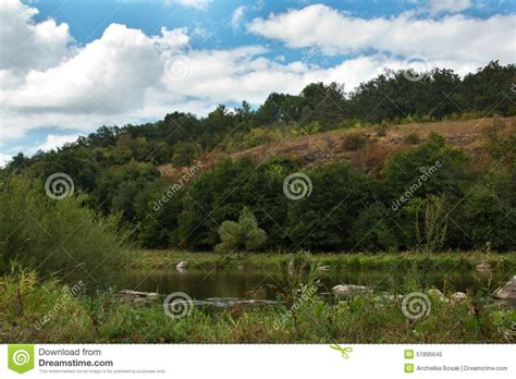 Landscape Of A Green Grassy Hills Trees River And Sky Stock Image