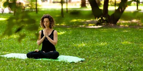 Attractive And Peaceful Woman Sitting In Yoga Lotus Position In The