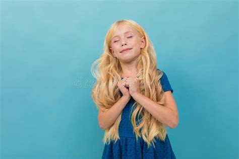 Little Girl With Blonde Hair In Blue Dress Is Relaxed And Enjoying