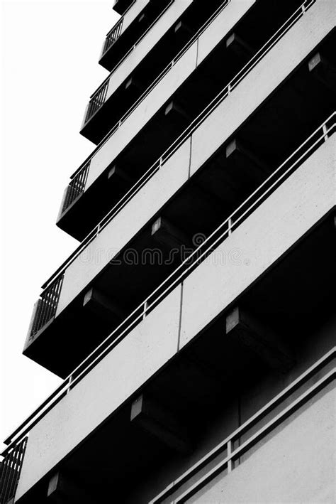 Vertical Low Angle Shot Of A Gray Building With Long Balconies Stock