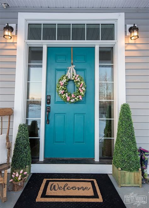 A Blue Front Door With A Welcome Mat And Wreath