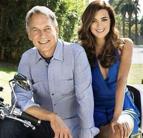 A Man And Woman Sitting On The Back Of A Motorbike Smiling At The Camera