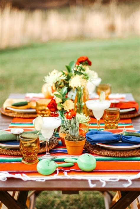 An Outdoor Table Set With Colorful Plates And Place Settings