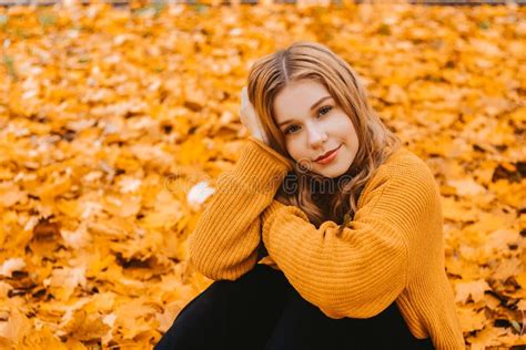 A Woman Is Sitting In An Autumn Park Girl Teenager On A Background Of