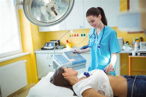 Enfermera Realizando Una Prueba De Electrocardiograma Al Paciente