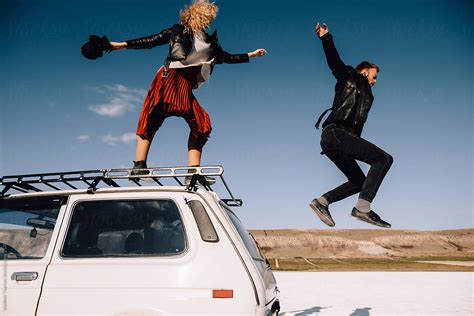 Couple Jumping From The Roof Of Their Overland Truck By Stocksy Contributor Vladimir Tsarkov