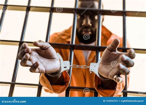 African American Prisoner In Handcuffs Behind Prison Stock Image