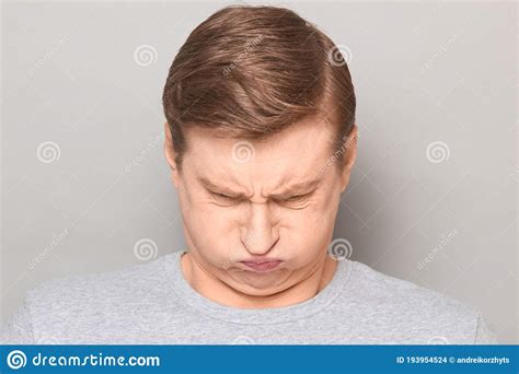 Portrait Of Funny Goofy Man Puffing Out His Cheeks And Pouting Lips