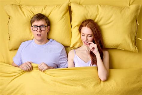 Happy Couple Lying In Bed Under Duvet After First Sex Experience Man Is Surprised By Skills Of