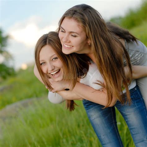 Two Teen Girl Friends Laughing Having Fun In Spring Or Summer Outdoors