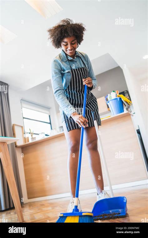 Afro Woman Sweeping Floor With Broom At Home Stock Photo Alamy