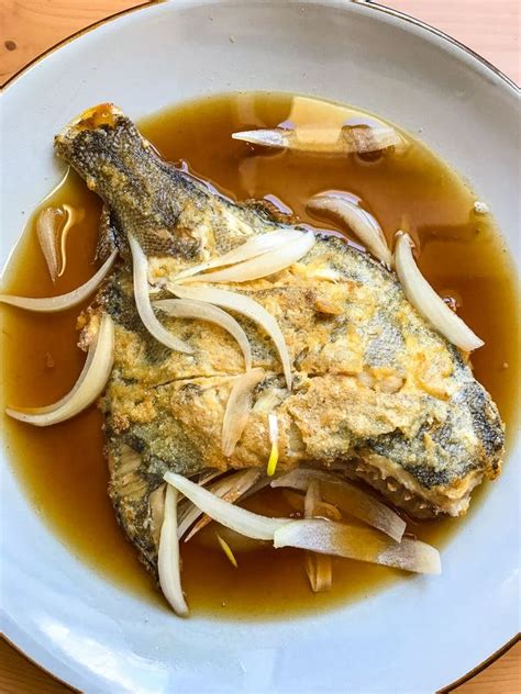 Deep Fried Flounder With Onions And Vegetables In Asian Sauce On A
