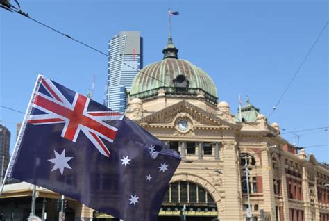 Australian Flag In Front Of Iconic Flinders Street Railway Station In