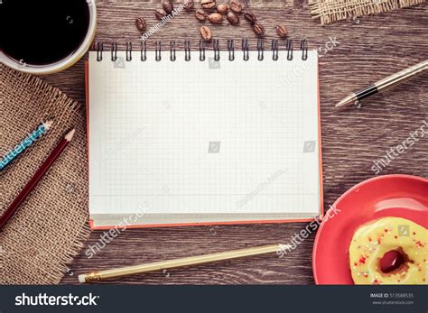 Opened Notepad And Cup Of Coffee With Donut On Wooden Table Ad