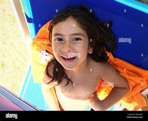 Portrait Of Happy Girl Leaning On Lounge Chair At Poolside Stock Photo Alamy