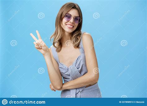 Charming Friendly And Outgoing Young Lady Showing Peace Or Victory