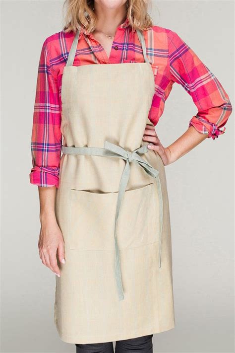 A Woman Wearing An Apron Posing For The Camera With Her Hands On Her
