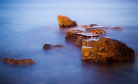 Brown Rock Formations Surrounded With Body Of Water Hd Wallpaper