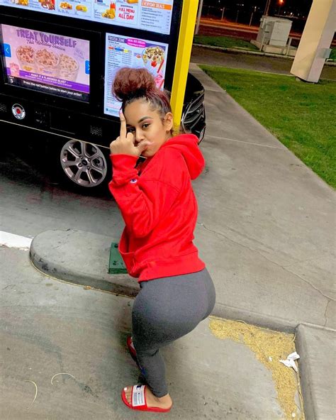 A Woman Squatting In Front Of A Vending Machine On The Side Of The Road