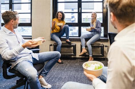 Employees Having Lunch Break At Coworking Office Stock Photo