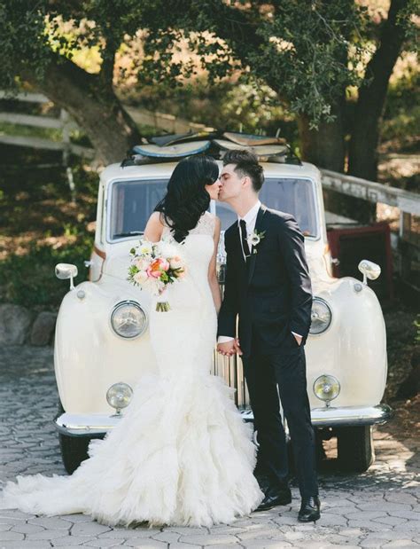 A Bride And Groom Kissing In Front Of An Old Truck