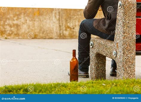 Man Depressed With Wine Bottle Sitting On Bench Outdoor Stock Image