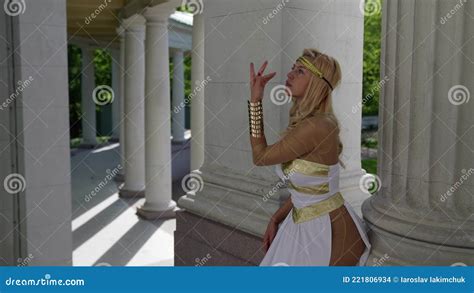 Blonde Woman Is Wearing Suit Of Aphrodite Is Posing Sexually Near Columns Of Palace Stock