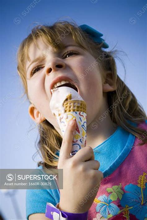 Young Girl Eating Ice Cream Cone Superstock