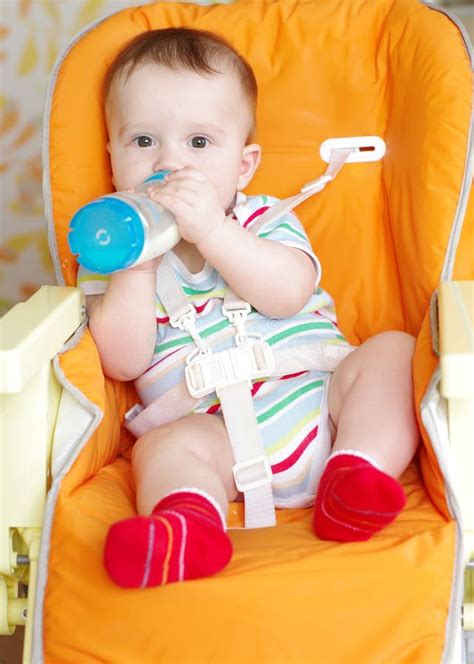 Baby With Feeding Bottle Sitting On Highchair Stock Image Image Of