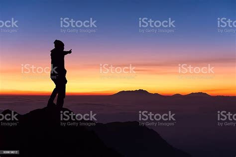 Silhouette Man Standing And Thumbs Up On Top Of Mountain Stock Photo