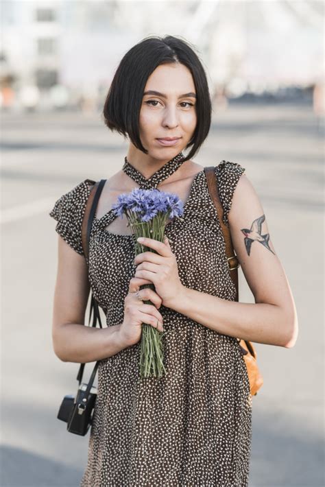 Free Young Woman With Tattoo Holding Flowers Nohatcc