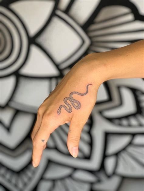 A Womans Hand With A Tattoo On It And A Snake In The Middle