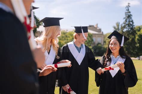Cheerful Graduating Students Glad Having Their Diplomas Stock Image