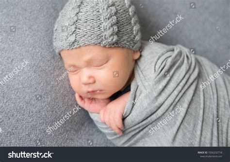 Royalty Free Newborn Baby Sleeping Curled Up In Grey Blanket