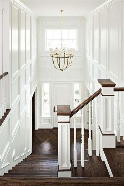 This Chic Two Story Foyer Features Walls Clad In Decorative Trim