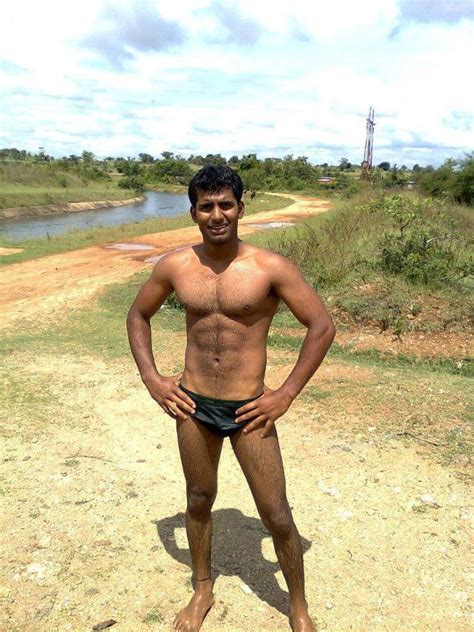 A Man Standing In The Dirt With His Hands On His Hips And No Shirt On