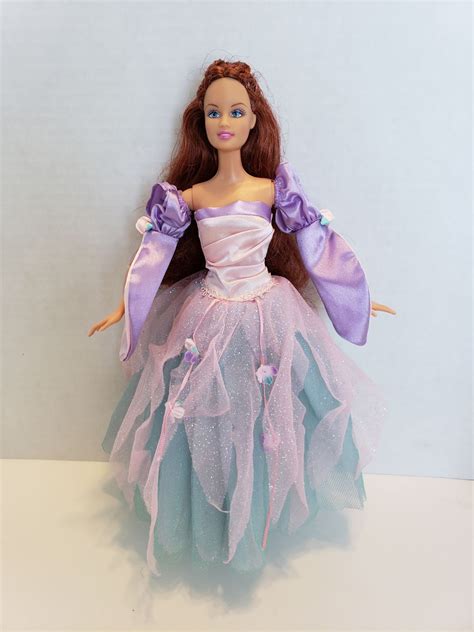 The Doll Is Wearing A Purple And Blue Dress