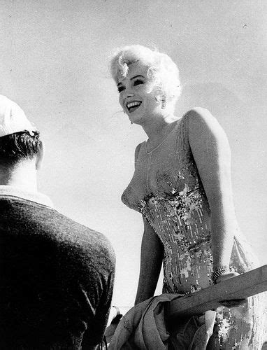 Marilyn Monroe Smiling While Standing Next To A Man