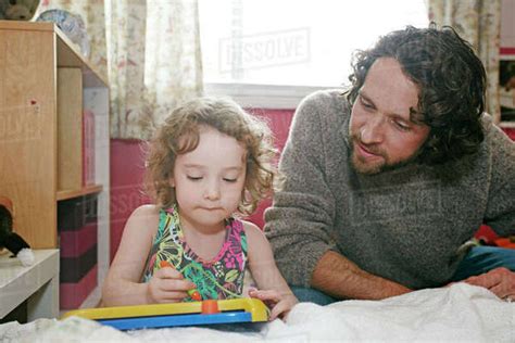 Caucasian Father And Daughter Playing In Bedroom Stock Photo Dissolve