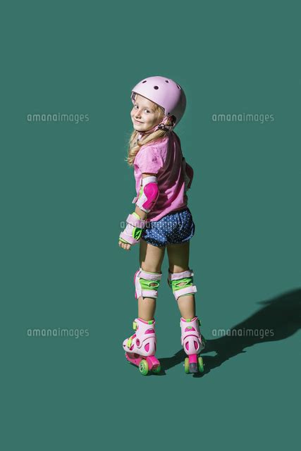 Portrait Smiling Girl Roller Skating Against Green Background