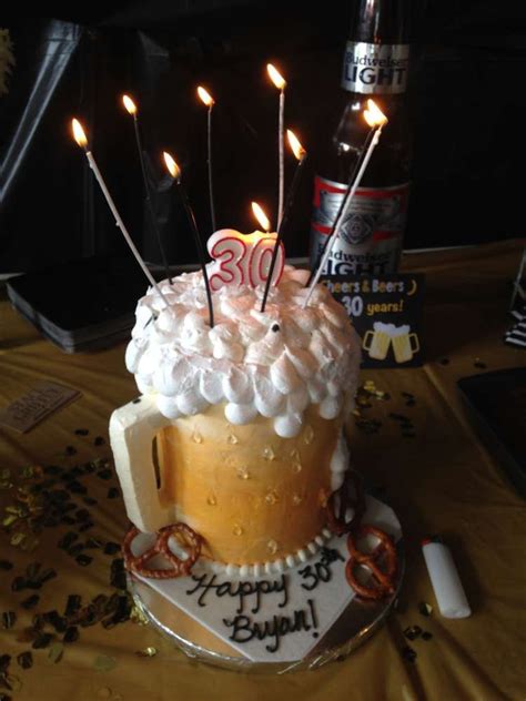 A Birthday Cake With Lit Candles On It Sitting On A Table Next To A Bottle