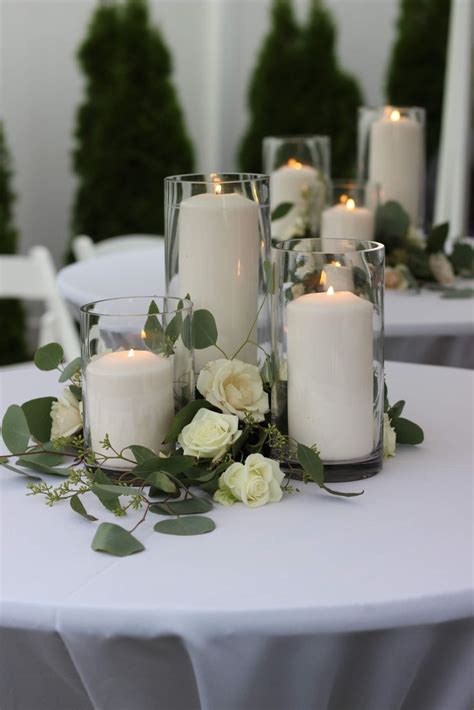 Glass Cylinders Filled With Candles And Surrounded By Greenery And Roses Romantic Wedding