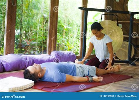 Young Beautiful And Exotic Asian Balinese Wellness Therapist Giving Body Thai Massage To