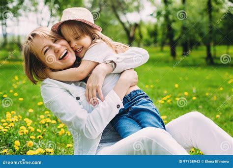 Hugging Happy Mother And Daughter For A Walk In The Park On The Green