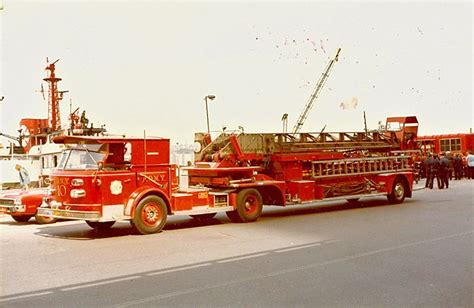 An Old Fire Truck Is Parked In Front Of A Boat