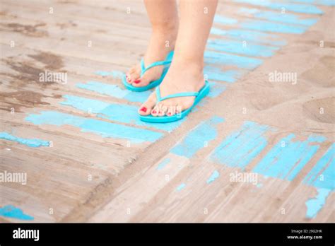 Lady S Feet With Red Nail Varnish In Sandals On The Sandy Beach By The