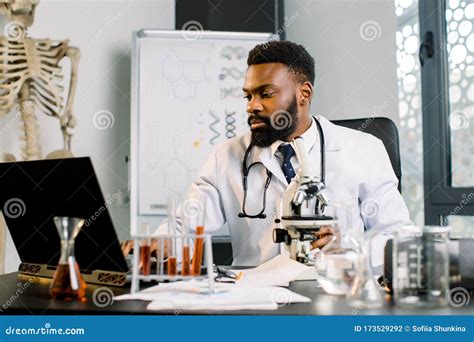 African American Scientist Doctor In White Coat Working With Microscope
