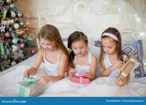 Child Girls Wake Up In Their Bed In Christmas Morning Stock Photo